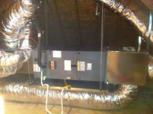 Furnace heating system in the attic of a house, surrounded by ductwork.