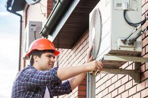 Technician servicing HVAC system outdoors.