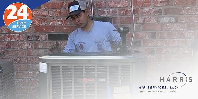 Technician servicing outdoor HVAC unit outside a brick home.