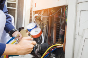 HVAC technician completing furnace maintenance on heating system.