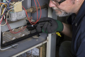 HVAC technician inspecting a home's furnace.