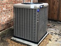 Outside AC unit next to brick home.