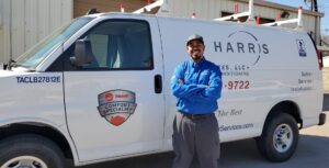 Harris Air Services HVAC technician standing in front of Harris Air Services truck.