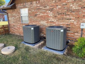 Two new AC units outside of brick house.