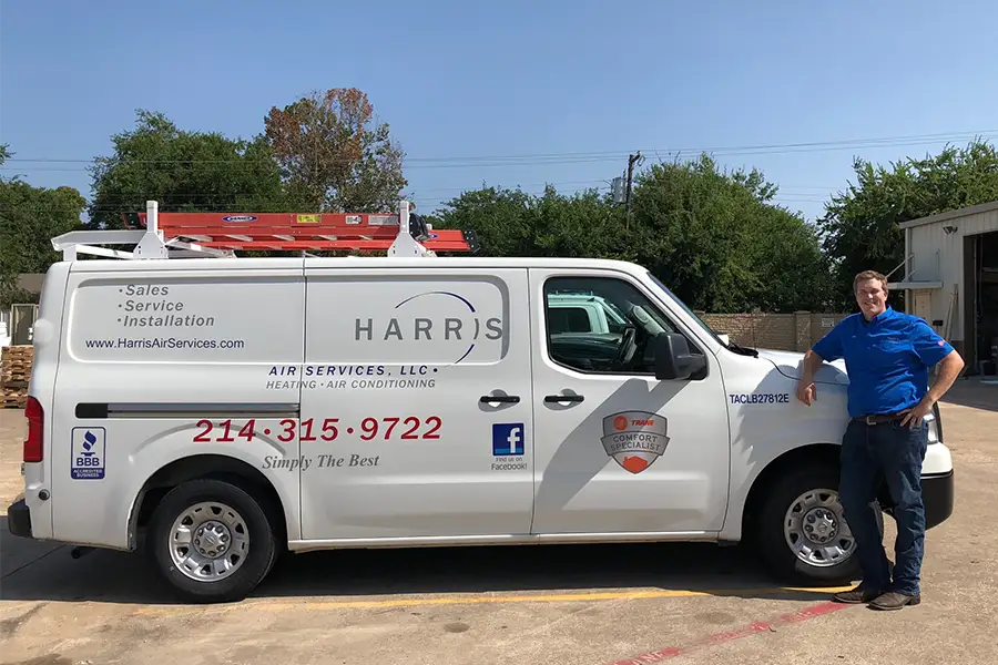 HVAC service technician standing by branded service van in McKinney TX