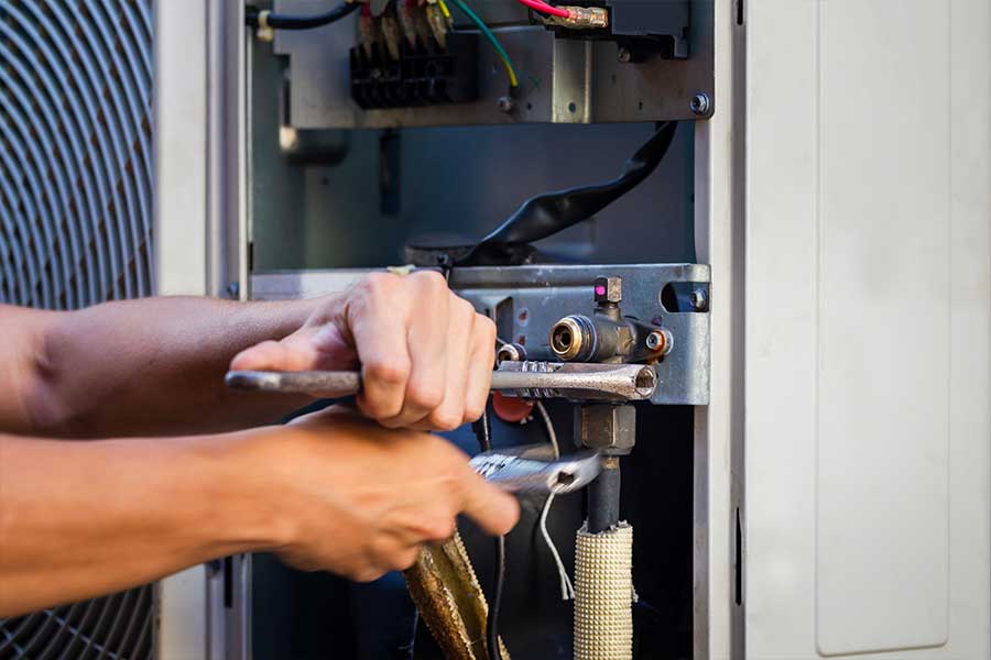 Technician repairing an HVAC component during HVAC repair in McKinney, TX